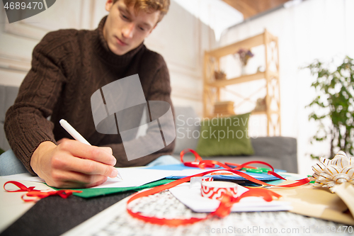 Image of Man making greeting card for New Year and Christmas 2021 for friends or family, scrap booking, DIY