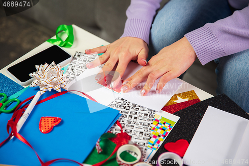 Image of Woman making greeting card for New Year and Christmas 2021 for friends or family, scrap booking, DIY