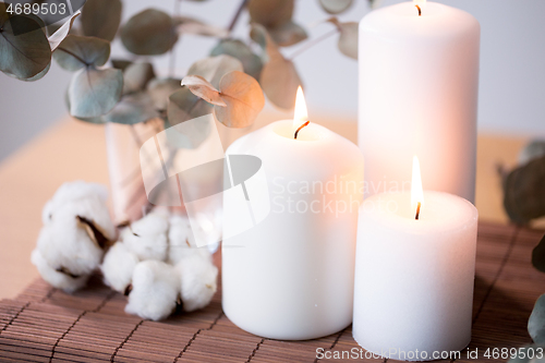 Image of candles and branches of eucalyptus on table