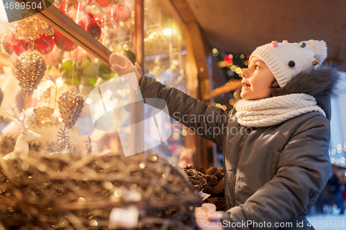 Image of girl choosing christmas decorations at market