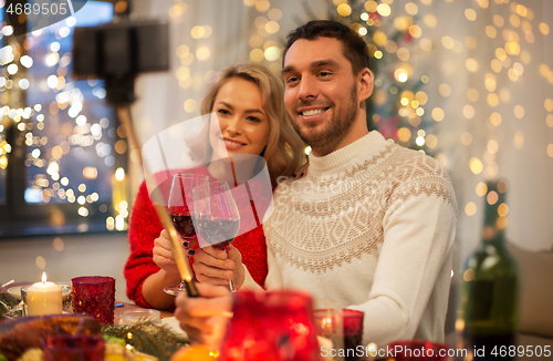 Image of couple taking picture by selfie stick at christmas