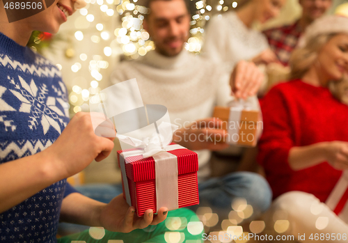 Image of close up of friends opening christmas gifts