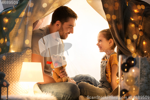 Image of happy family playing with toy in kids tent at home