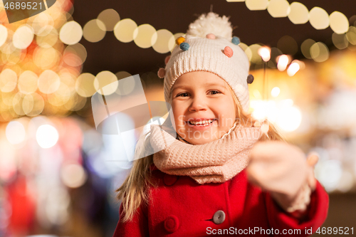 Image of happy girl with sparkler at christmas market