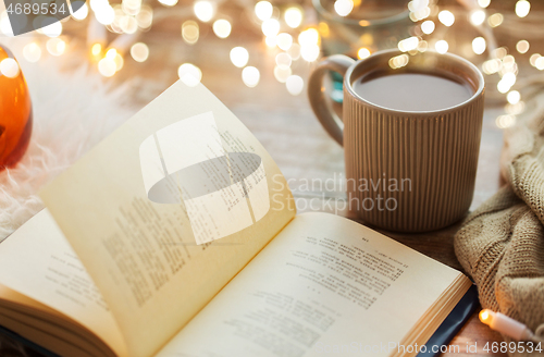 Image of book and cup of coffee or hot chocolate on table