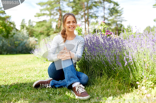 Image of young woman and lavender flowers at summer garden