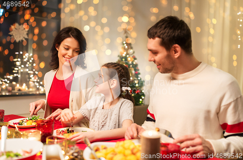 Image of happy family having christmas dinner at home