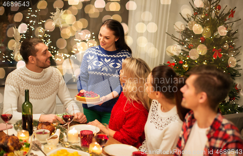 Image of happy friends having christmas dinner at home