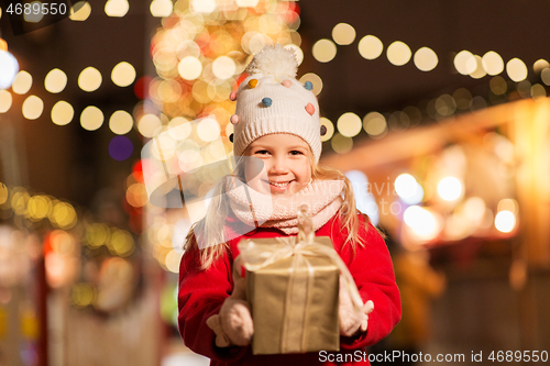 Image of happy girl with gift box at christmas market