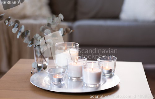 Image of burning fragrance candle on table at cozy home
