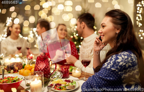 Image of woman calling on smartphone at christmas dinner