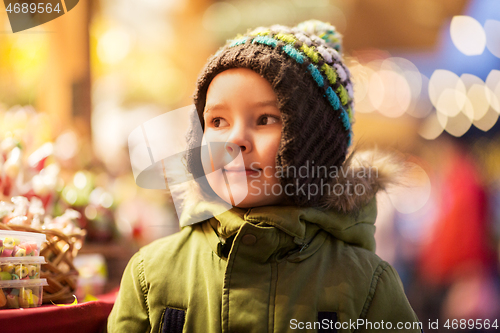 Image of happy little boy at christmas market in winter