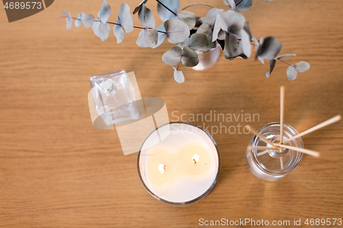 Image of aroma reed diffuser, burning candle and perfume