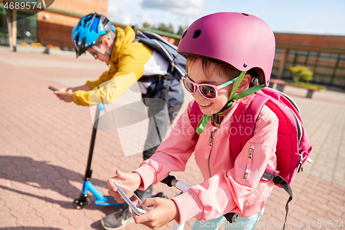 Image of school children with smartphones and scooters