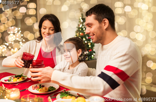 Image of happy family having christmas dinner at home