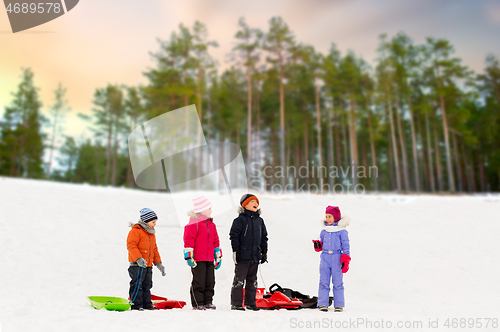 Image of happy little kids with sleds in winter