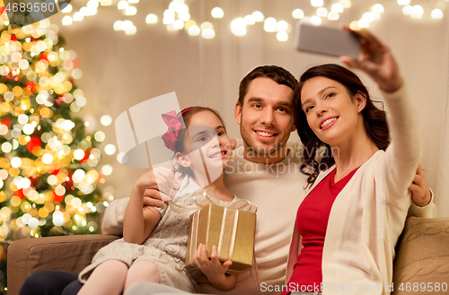 Image of happy family with christmas present at home