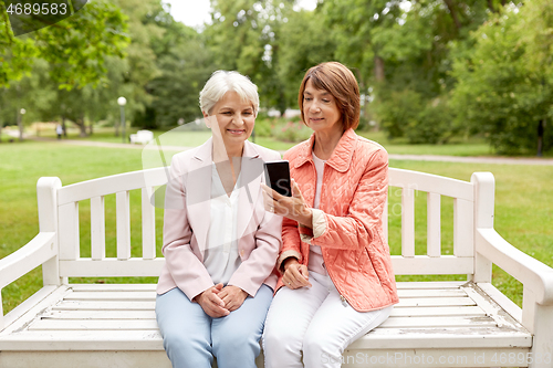 Image of happy senior women with smartphone at summer park