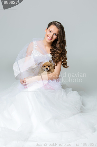 Image of beautiful bride girl with spitz bride on gray background