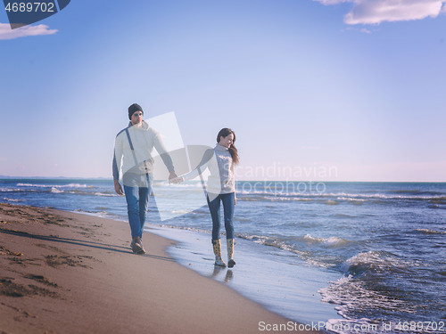 Image of Loving young couple on a beach at autumn sunny day