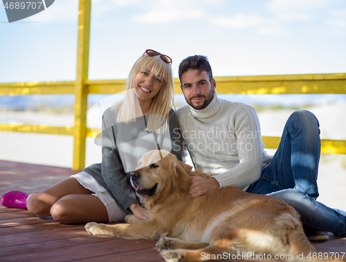 Image of Couple with dog enjoying time on beach