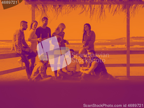 Image of Group of friends having fun on autumn day at beach