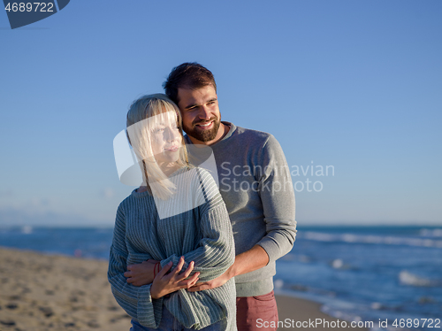 Image of Loving young couple on a beach at autumn sunny day