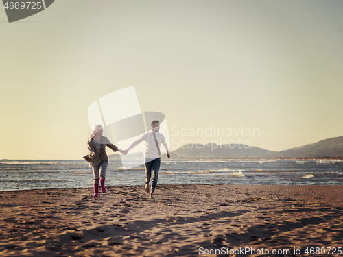 Image of Loving young couple on a beach at autumn sunny day