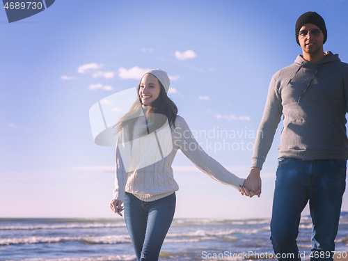 Image of Loving young couple on a beach at autumn sunny day