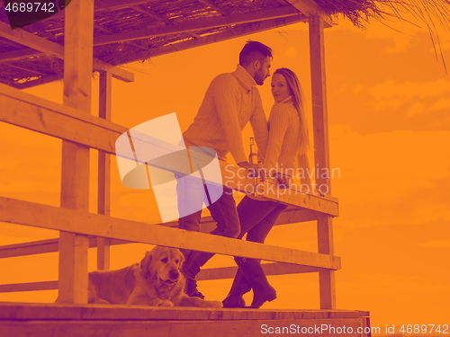 Image of young couple drinking beer together at the beach