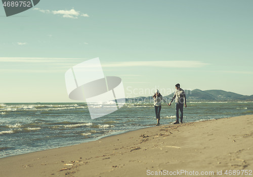 Image of Loving young couple on a beach at autumn sunny day