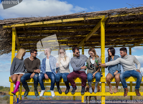 Image of Group of friends having fun on autumn day at beach