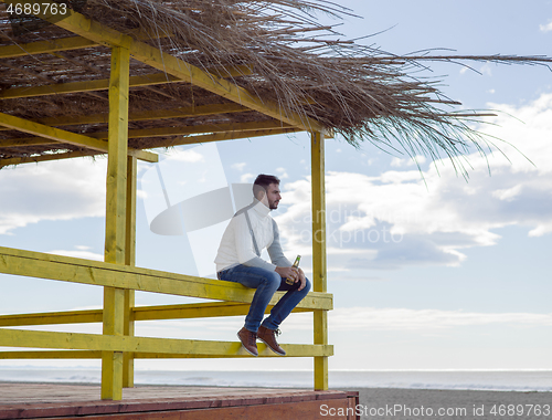 Image of man drinking beer at the beach