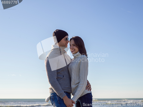 Image of Loving young couple on a beach at autumn sunny day