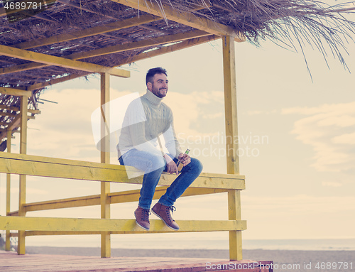 Image of man drinking beer at the beach