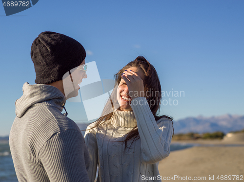 Image of Loving young couple on a beach at autumn sunny day