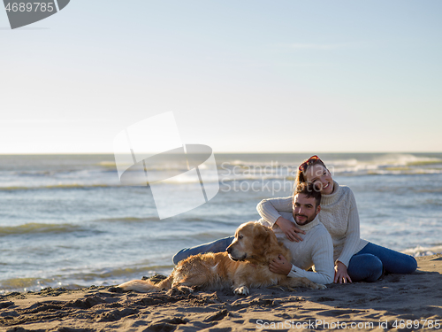 Image of Couple with dog enjoying time on beach