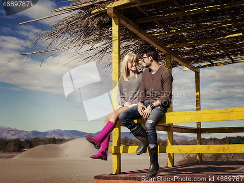 Image of young couple drinking beer together at the beach