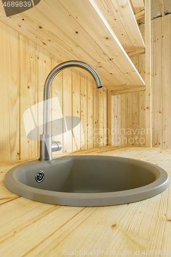 Image of Sink with mixer close-up in the interior of a wooden house