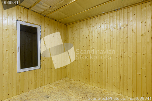 Image of Fragment of a room, finished with wooden clapboard, with a window