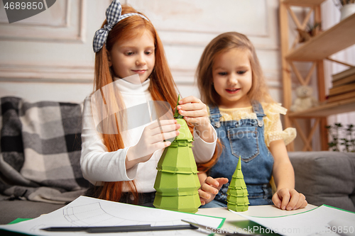 Image of Two little children, girls together in creativity of the house. Happy kids make handmade toys for games or New Year celebration