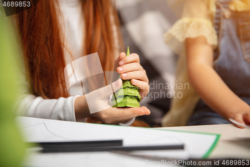 Image of Close up hands of two little children, girls together in creativity of the house. Kids make handmade toys for games or New Year celebration