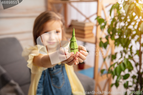 Image of Little girl in creativity of the house. Happy kid makes handmade toys for games or New Year celebration