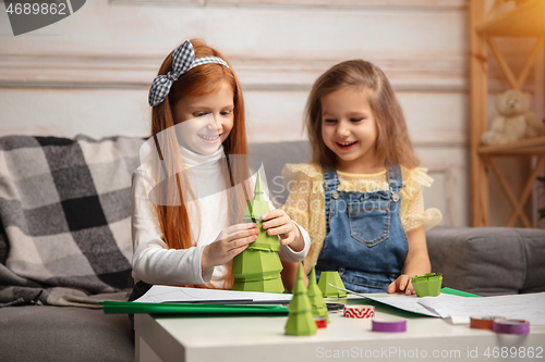 Image of Two little children, girls together in creativity of the house. Happy kids make handmade toys for games or New Year celebration