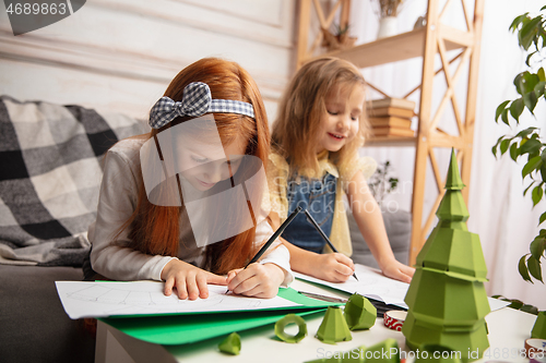 Image of Two little children, girls together in creativity of the house. Happy kids make handmade toys for games or New Year celebration