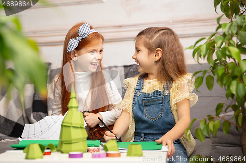 Image of Two little children, girls together in creativity of the house. Happy kids make handmade toys for games or New Year celebration