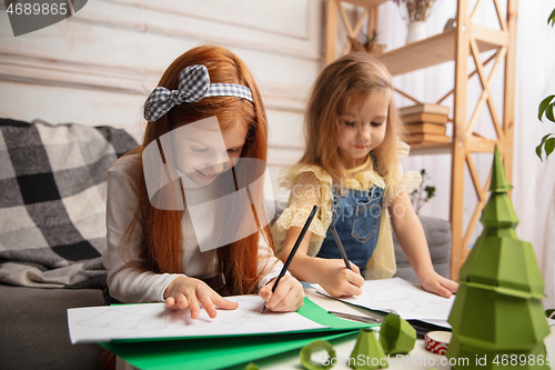 Image of Two little children, girls together in creativity of the house. Happy kids make handmade toys for games or New Year celebration