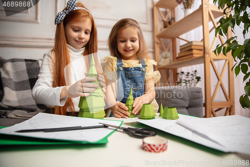 Image of Two little children, girls together in creativity of the house. Happy kids make handmade toys for games or New Year celebration