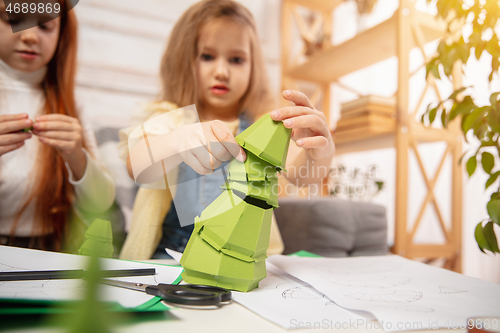 Image of Two little children, girls together in creativity of the house. Happy kids make handmade toys for games or New Year celebration