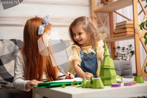 Image of Two little children, girls together in creativity of the house. Happy kids make handmade toys for games or New Year celebration